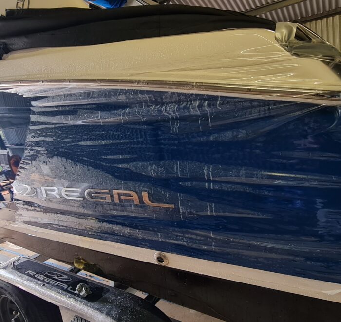 Blue Regal speedboat undergoing a custom marine vinyl wrap installation and colour change