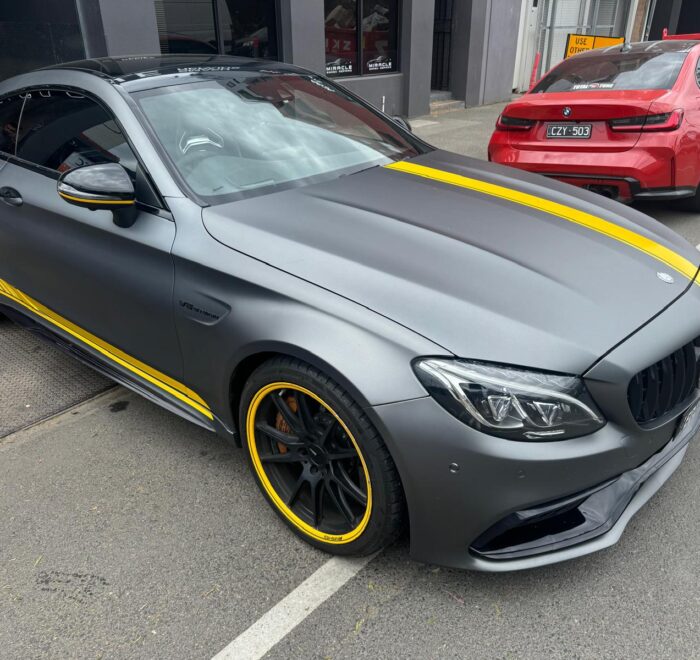Mercedes-AMG C63 finished in a satin grey vehicle wrap with custom yellow racing stripes and accent graphics Brunswick