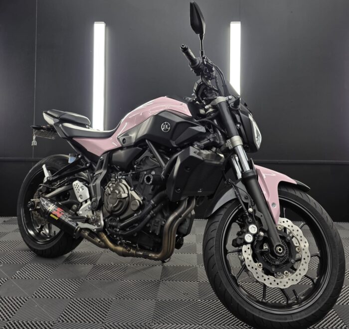 Yamaha MT-07 motorcycle wrapped in gloss pastel pink vinyl with black accents, photographed in a professional detailing and wrapping studio South Yarra.