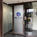 SME Powered Services office entry door with custom window frosting and corporate branding graphics in Port Melbourne