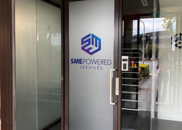SME Powered Services office entry door with custom window frosting and corporate branding graphics in Port Melbourne